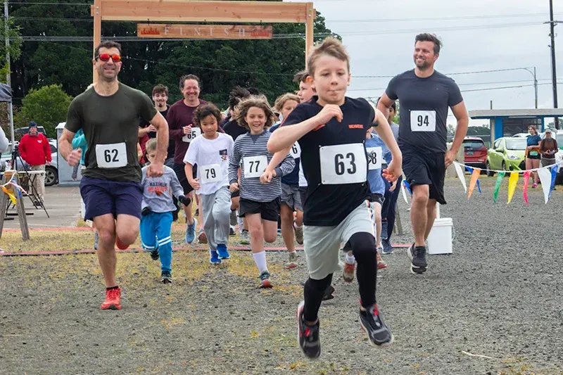 Kids race start with young runners charging toward the finish line